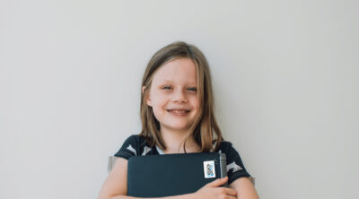 Photo of a girl holding a laptop.